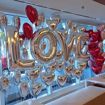 Фотозона из фольгированных сердец с надписью "LOVE"